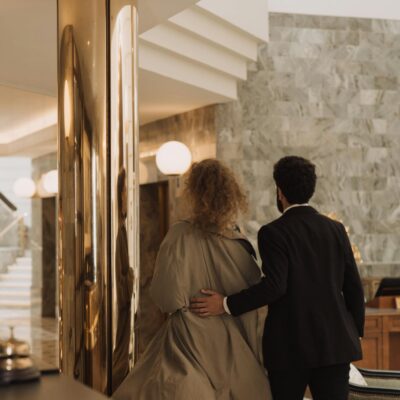 A couple walking in a luxurious hotel lobby, showcasing elegance and sophistication.