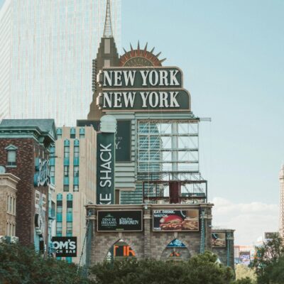 Daytime view of the New York-New York Hotel sign with surrounding architecture in Las Vegas.