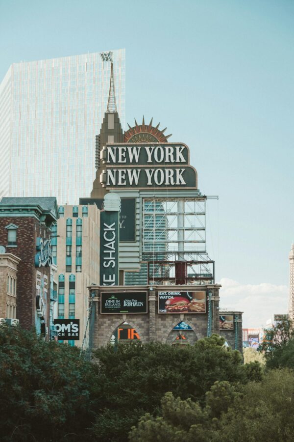 Daytime view of the New York-New York Hotel sign with surrounding architecture in Las Vegas.